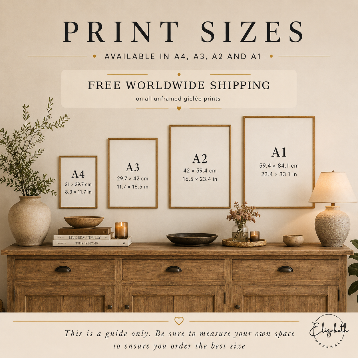 A framed print size guide poster showing A4, A3, A2, and A1 dimensions in both inches and centimeters, styled in a warm home interior above a wooden console table with vases, books, candles, and a lamp.