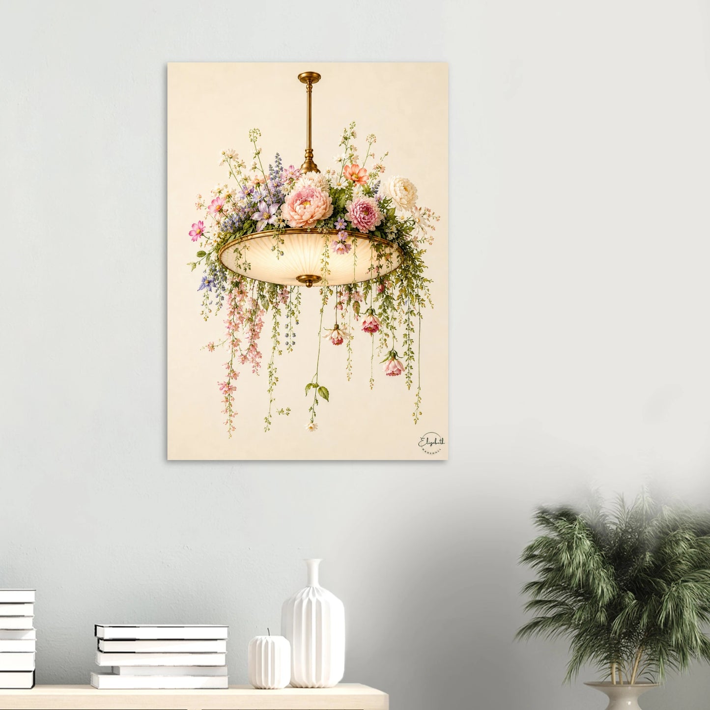 A vertical wall art print depicting a vintage floral chandelier with pink and purple flowers, hanging on a light gray wall above a styled shelf with books, a vase, and a potted plant.