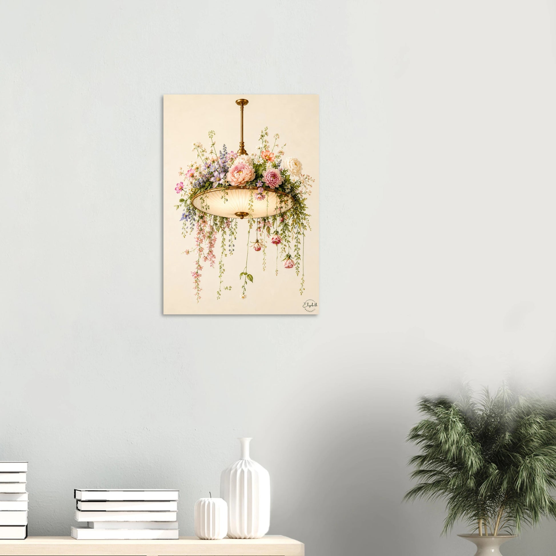 A vertical canvas art print featuring a vintage-style illustration of a hanging flower basket with pink and purple blossoms, displayed on a light gray wall above a styled shelf with books, white vases, and a potted plant.