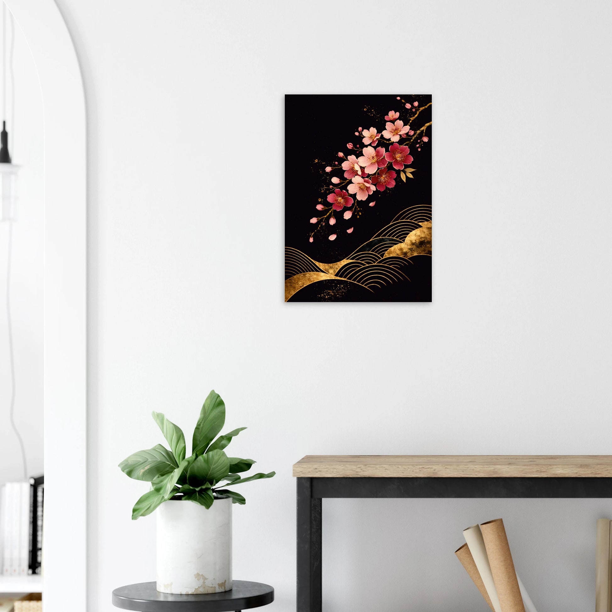 A vertical wall art print depicting a pink cocktail splash in a coupe glass with an orange slice, displayed on a white wall above a wooden table and next to a potted plant.