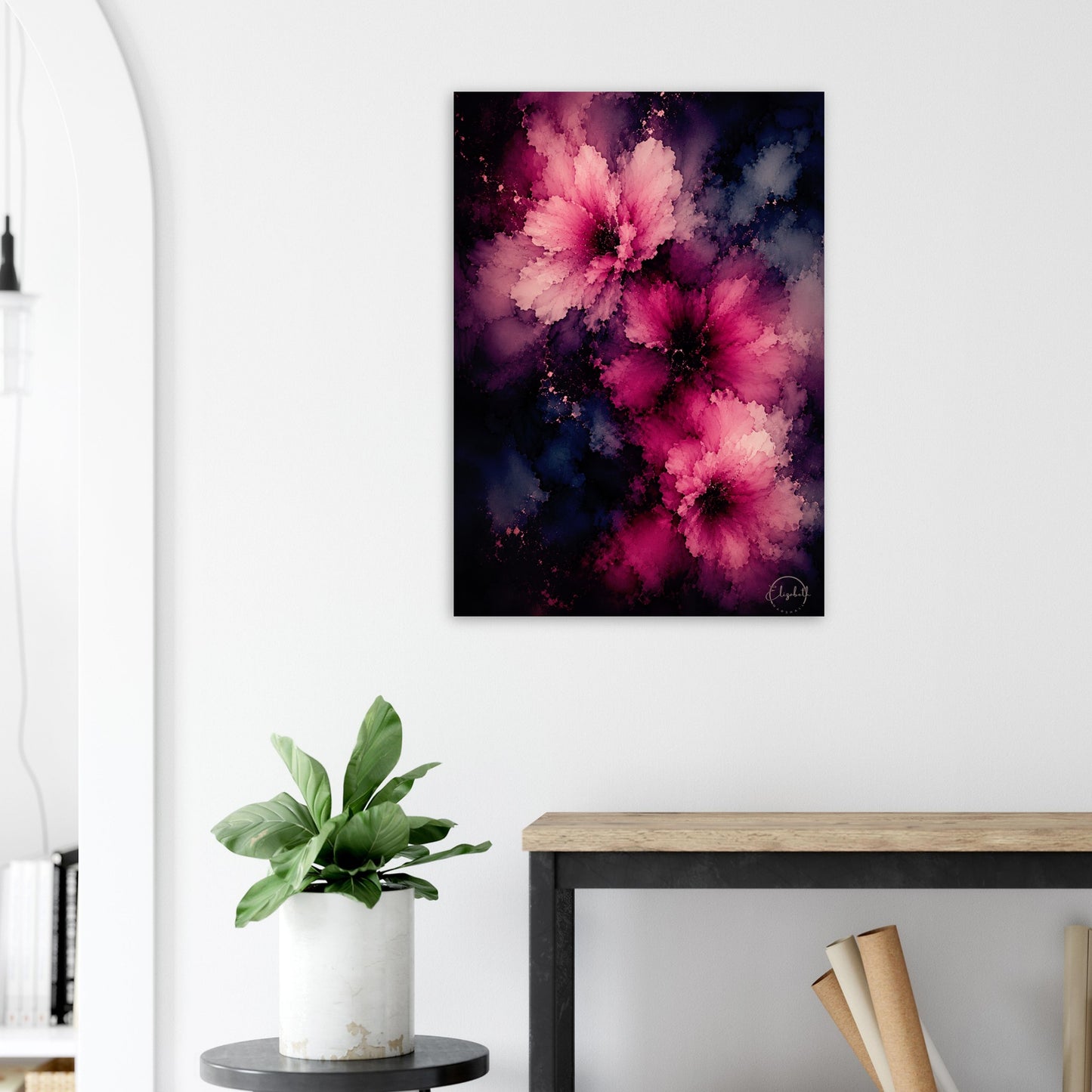 A vertical canvas wall art print featuring abstract pink and magenta flowers against a dark navy and black background, styled in a modern room setting above a console table with a potted plant.
