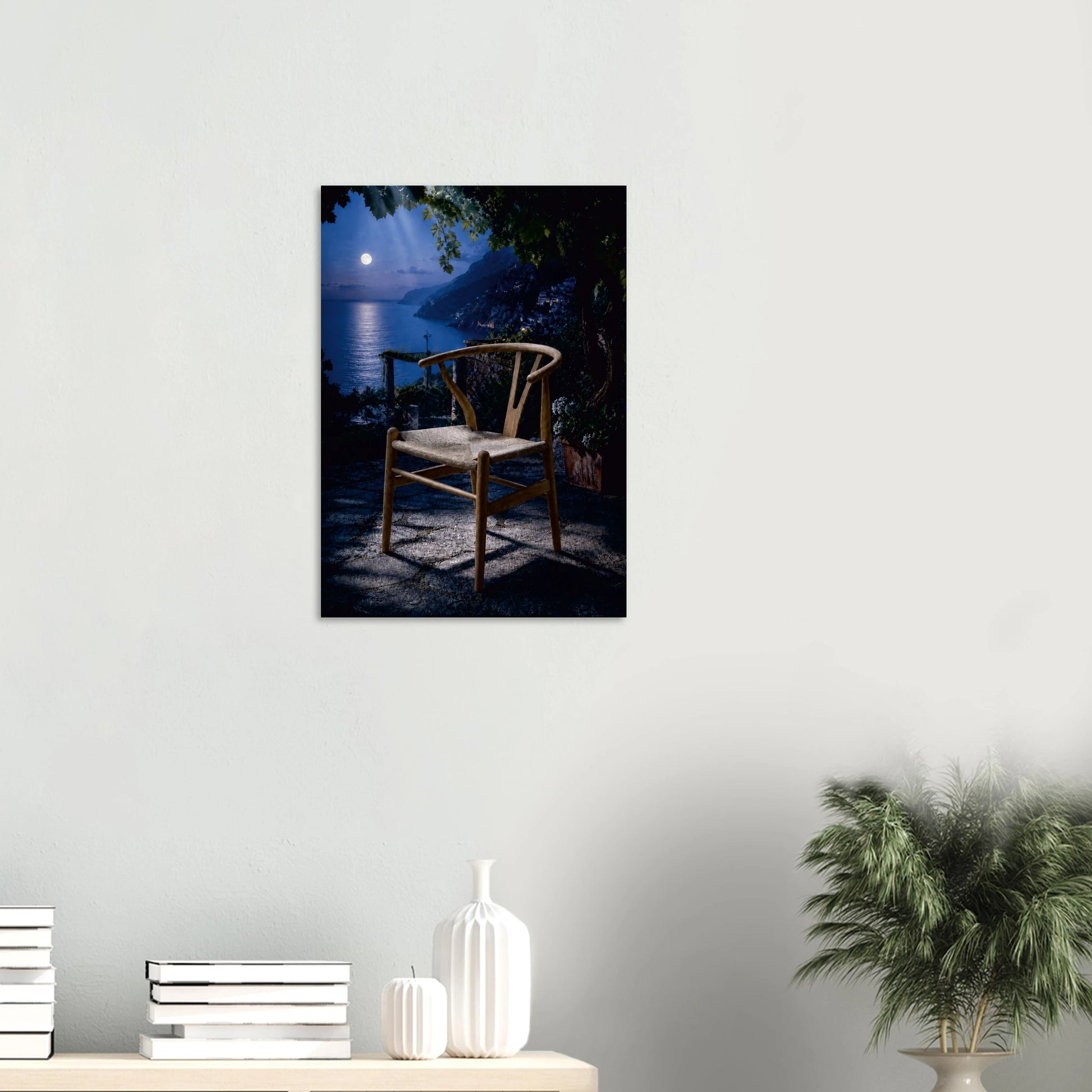 Wishing for a Moonlight Serenade is a love note to retro fans worldwide. A Wishbone Chair-inspired piece in warm natural wood sits alone on a moonlit terrace, the full moon hanging low over the water beyond, its reflection pooling across the deep midnight blue. Dark foliage presses in at the edges, a lantern glows softly to one side, and the whole scene holds its breath. It is the most romantic chair in the most romantic place, and it is waiting for someone to sit down and stay a while.