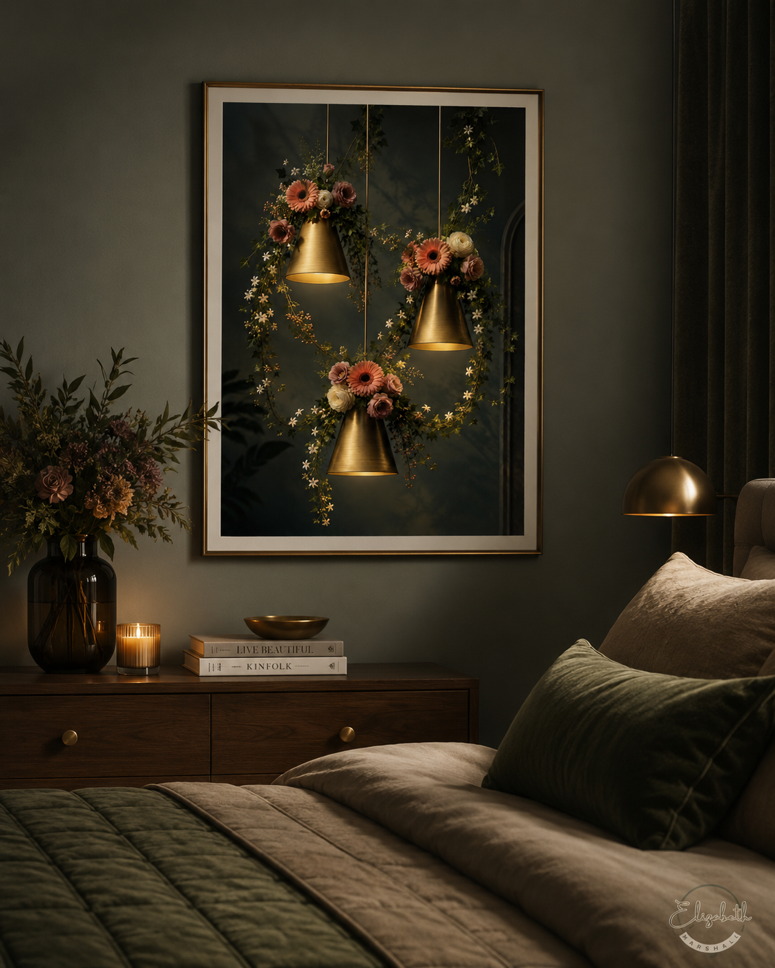 A framed wall art print hangs above a bed in a dark, elegant bedroom. The artwork depicts three hanging brass bells surrounded by pink and peach flowers and green vines against a dark background.