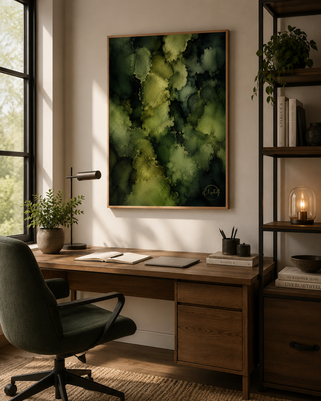A framed abstract green and yellow painting hangs on a beige wall above a wooden desk in a modern home office setting with a chair, lamp, and shelving.