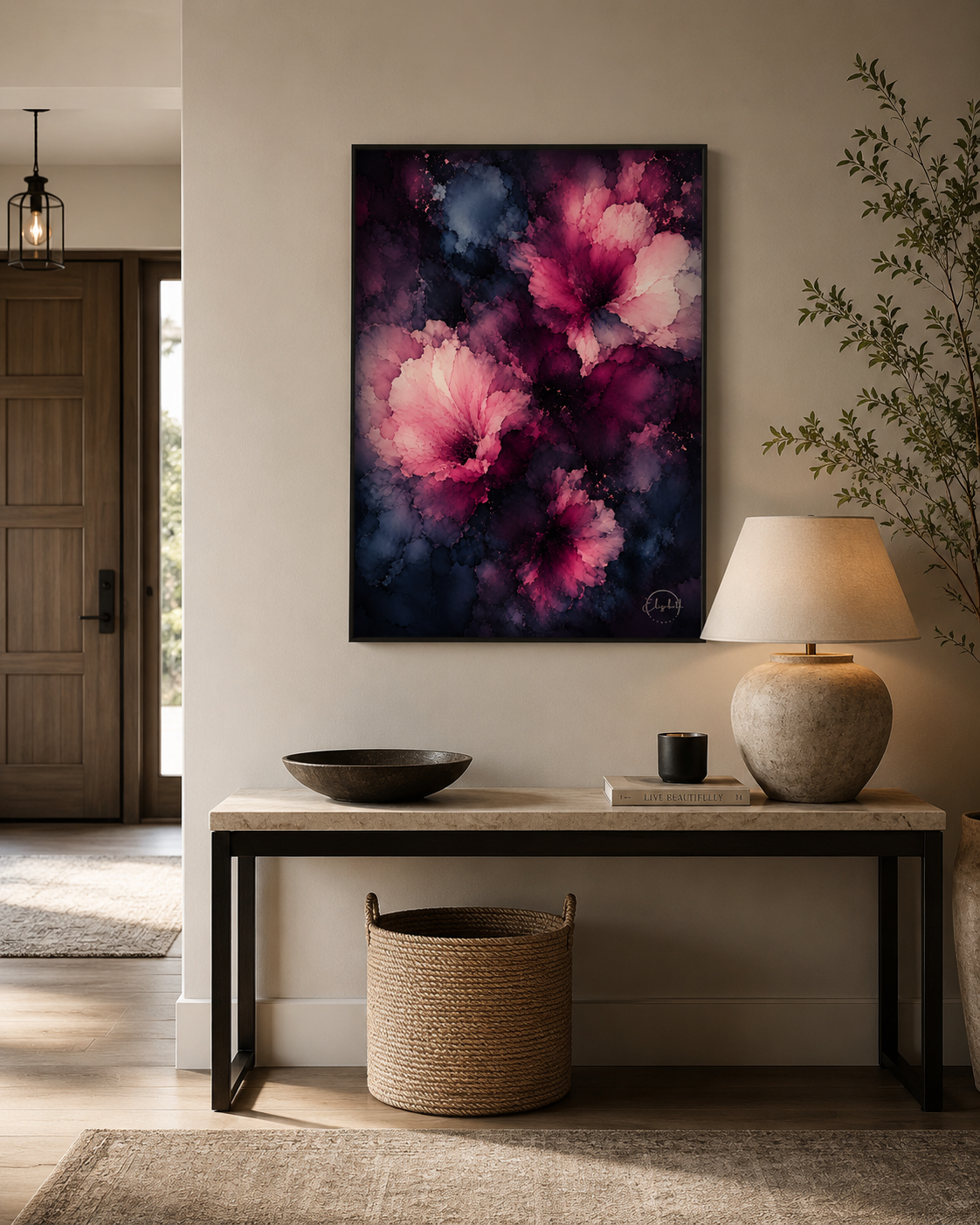 A vertical framed canvas print featuring large pink and purple flowers on a dark navy background, displayed on a beige wall above a console table in a styled home interior.
