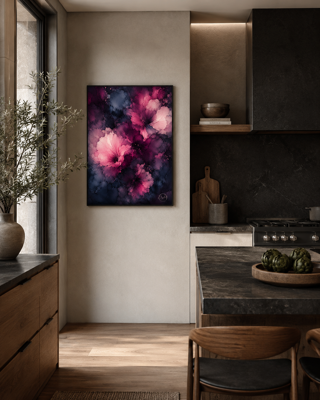 A framed abstract floral painting with vibrant pink, magenta, and purple blossoms on a dark navy background, displayed on a beige wall in a modern kitchen setting.