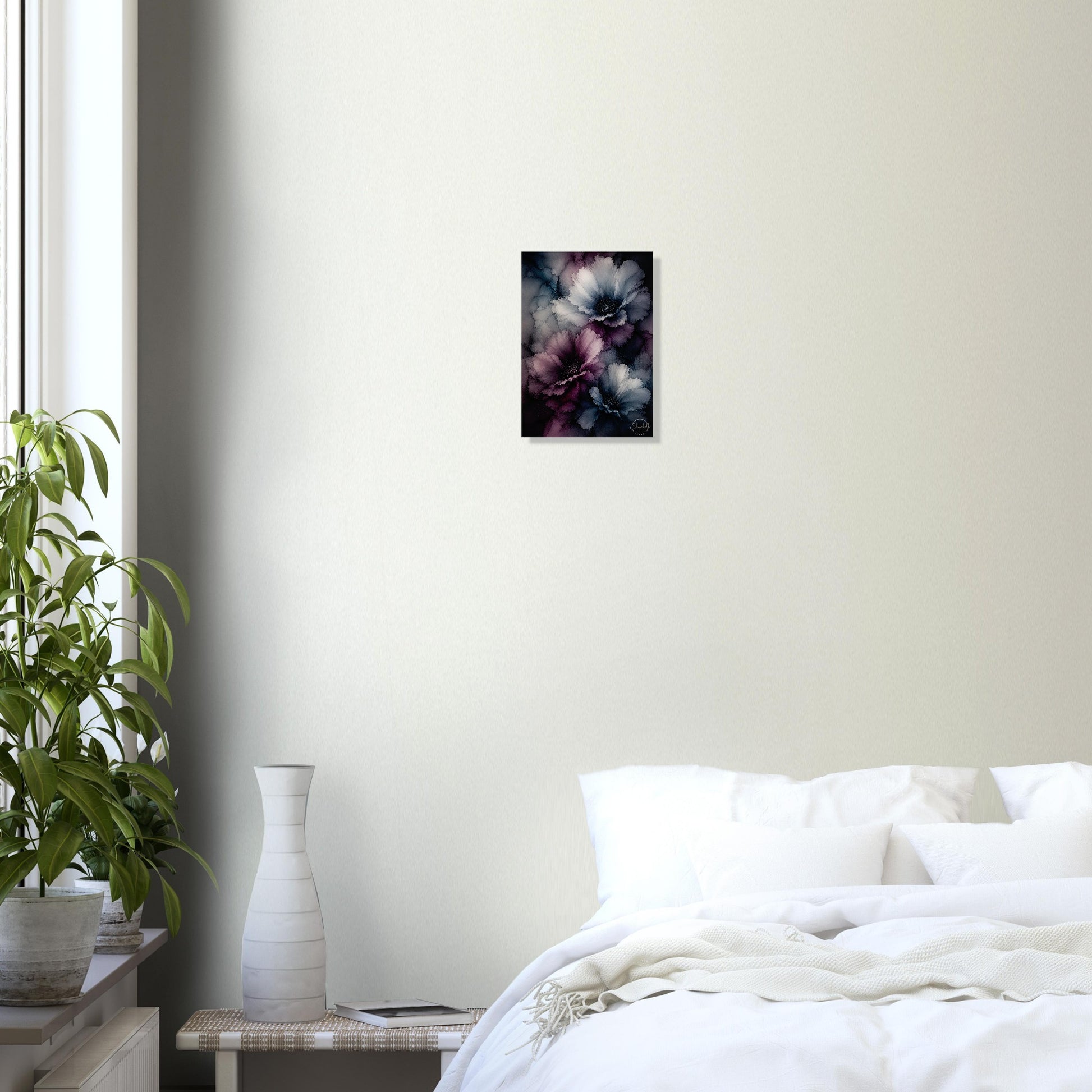 A small framed wall art print featuring dark blue, purple, and pink abstract floral shapes, displayed on a light beige wall above a bed in a modern, minimalist bedroom setting.