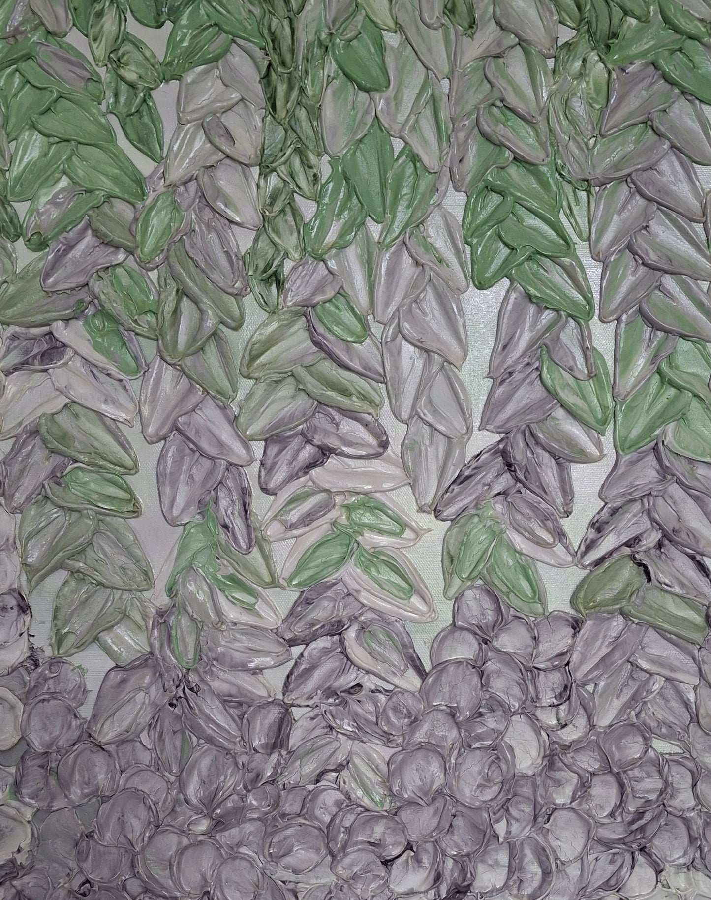 A close-up of a textured surface featuring rows of green and lilac flower petals arranged in a patterned layout on a light background.