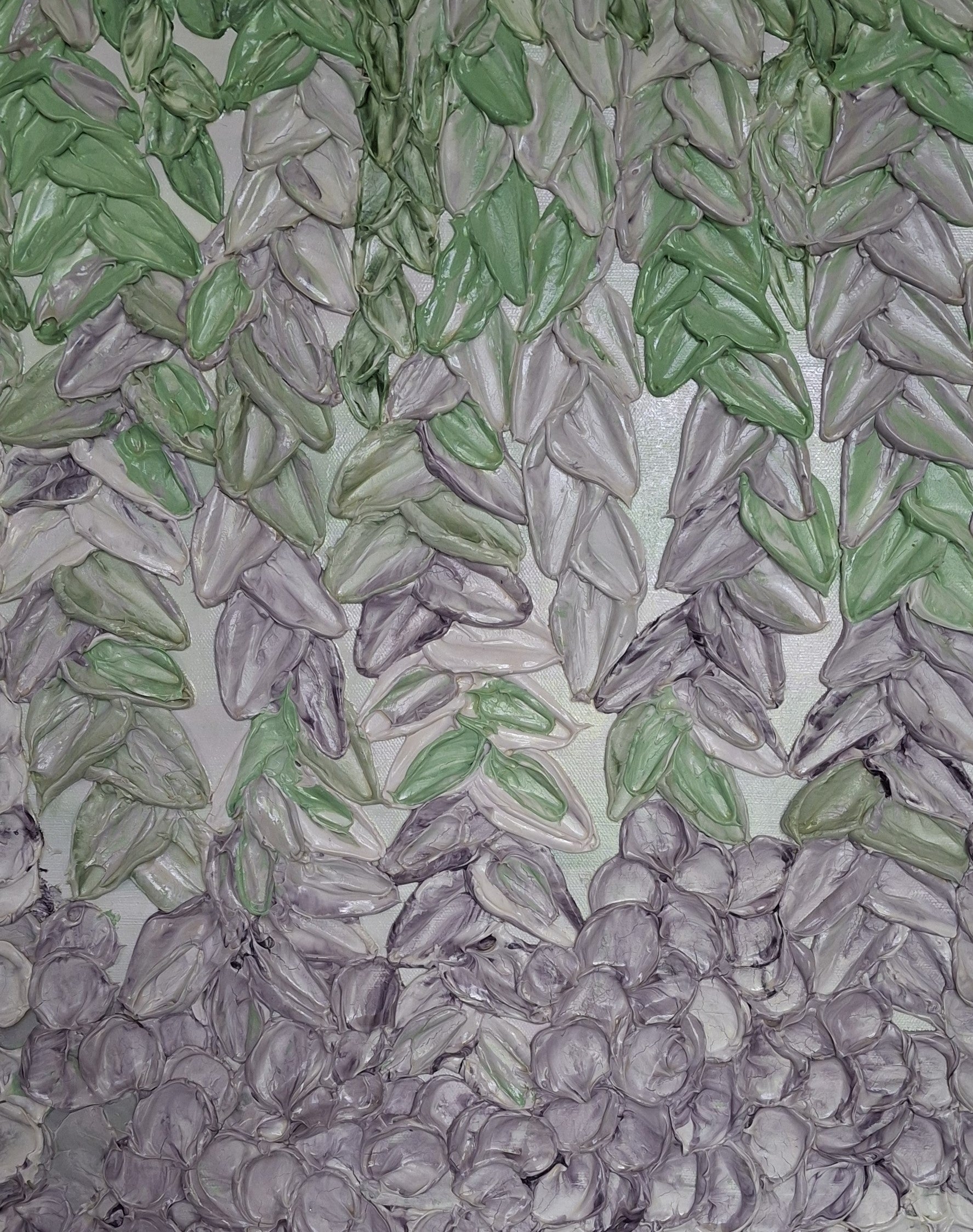 A close-up of a textured surface featuring rows of green and lilac flower petals arranged in a patterned layout on a light background.