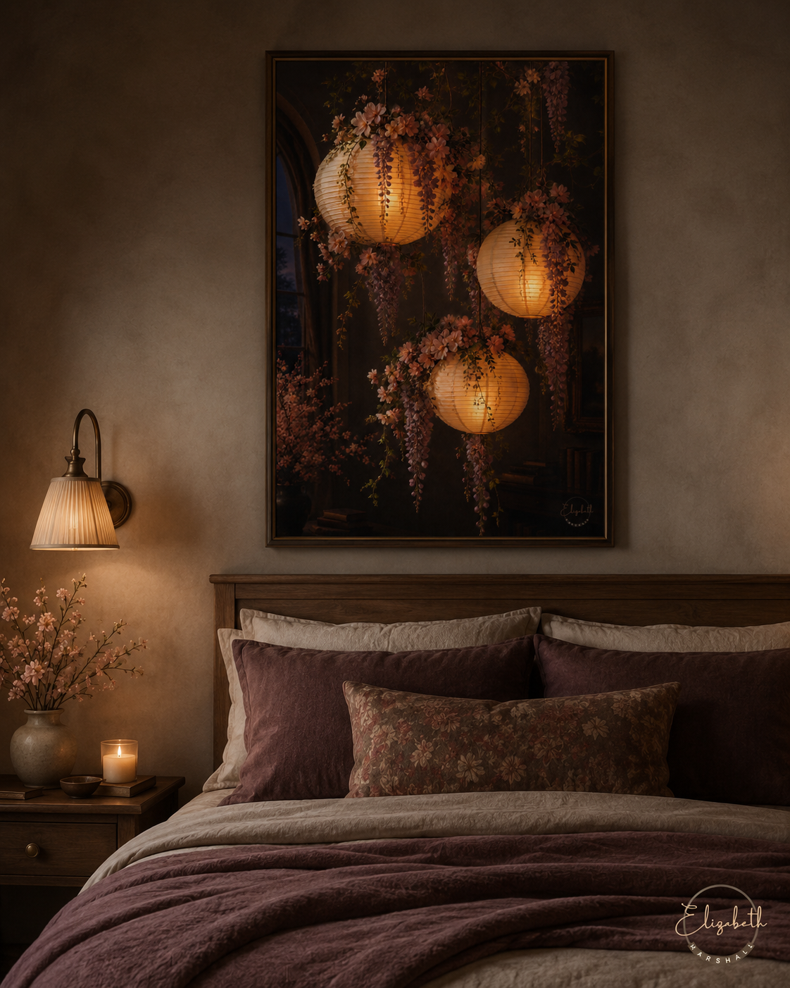 A framed wall art print depicting glowing hanging lanterns and wisteria flowers, displayed above a bed in a cozy, dimly lit bedroom with mauve bedding, a bedside lamp, and a candle.