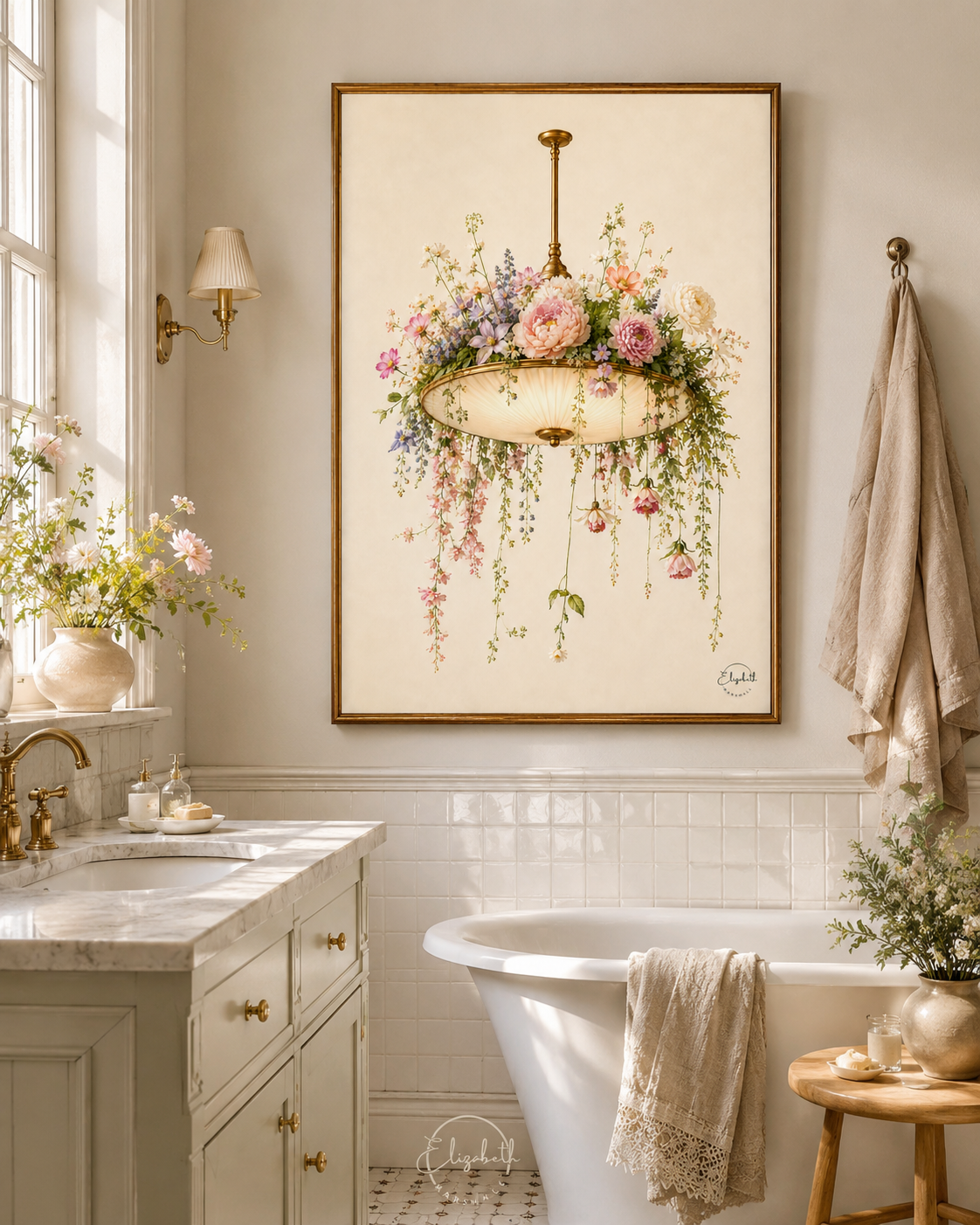 A framed art print depicting a vintage floral chandelier with pink and purple flowers and green foliage, hanging on a beige wall in a bright, classic bathroom with a white freestanding tub, marble vanity, and a beige towel.