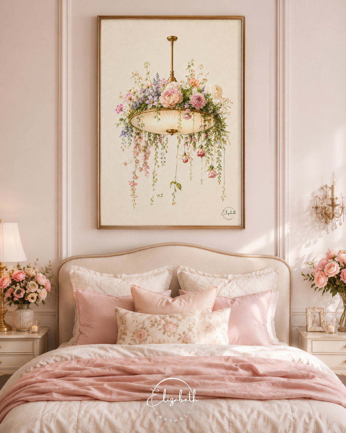 A framed wall art print depicting a hanging floral chandelier with pink flowers and green leaves, displayed above a neatly made bed in a soft pink bedroom.
