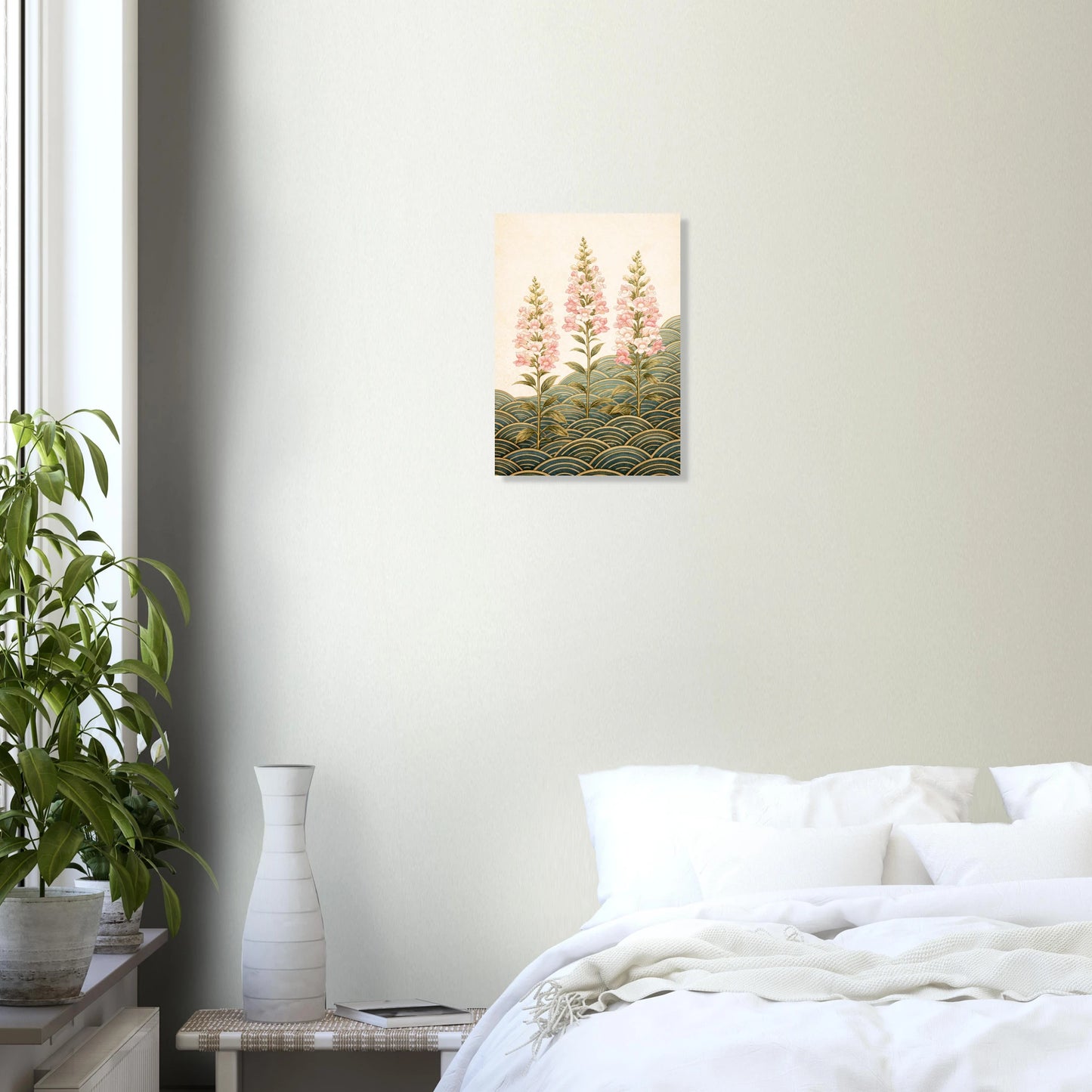 A small vertical wall art print showing pink flowers over green and gold wave-like patterns, displayed above a bed in a softly lit bedroom with a plant and vase nearby.
