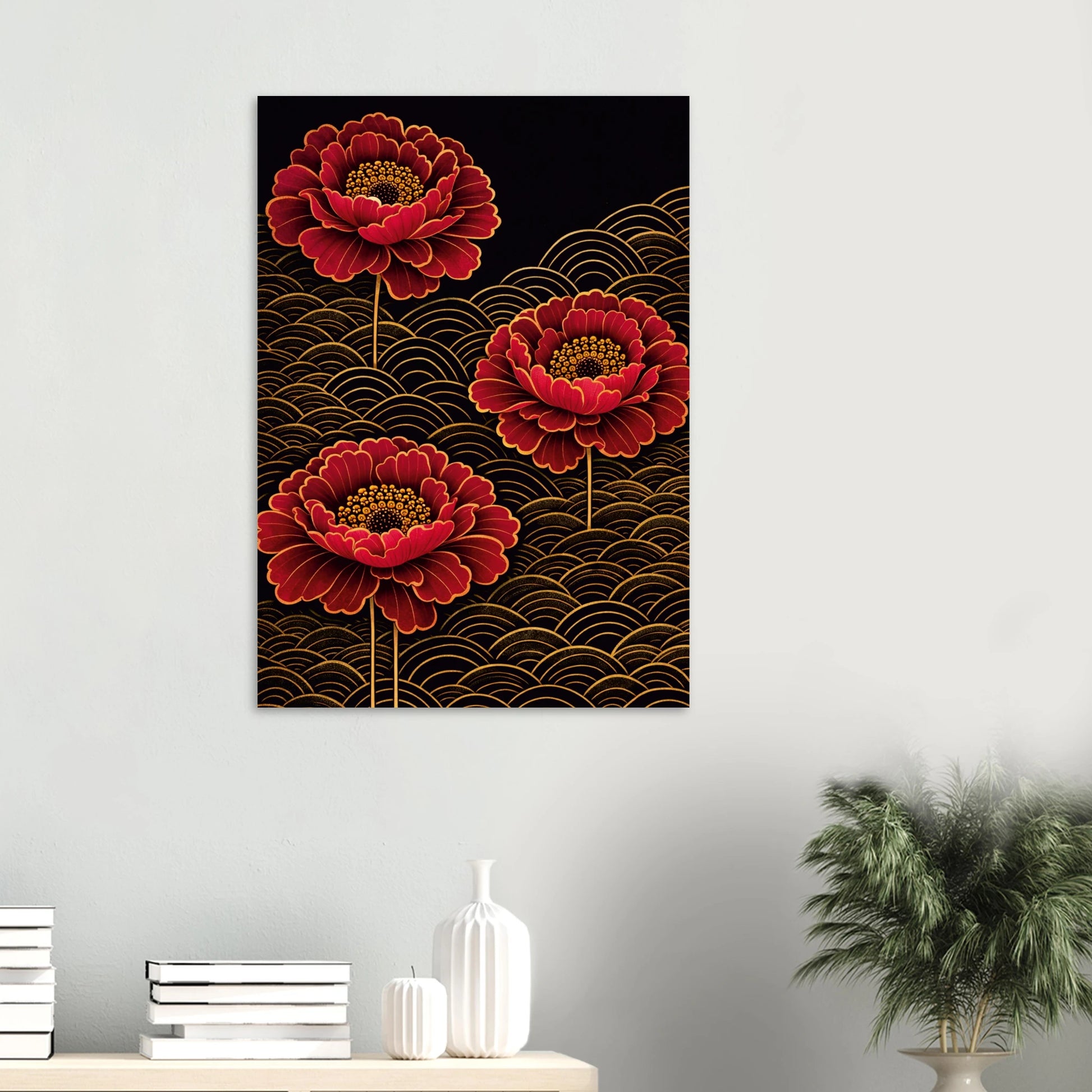 A vertical wall art print featuring three large red peony-like flowers with gold outlines on a black background with gold wave patterns, displayed on a light gray wall above a console table with books, vases, and a plant.