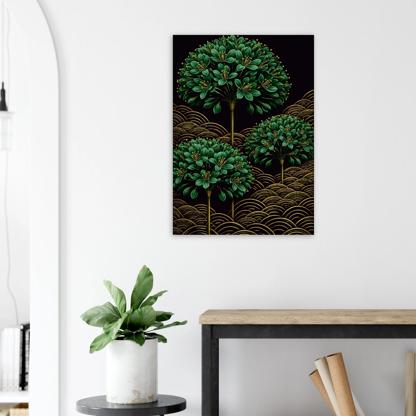 A vertical wall art print featuring three green leafy tree canopies above gold wave patterns on a black background, displayed on a white wall above a console table with a potted plant.