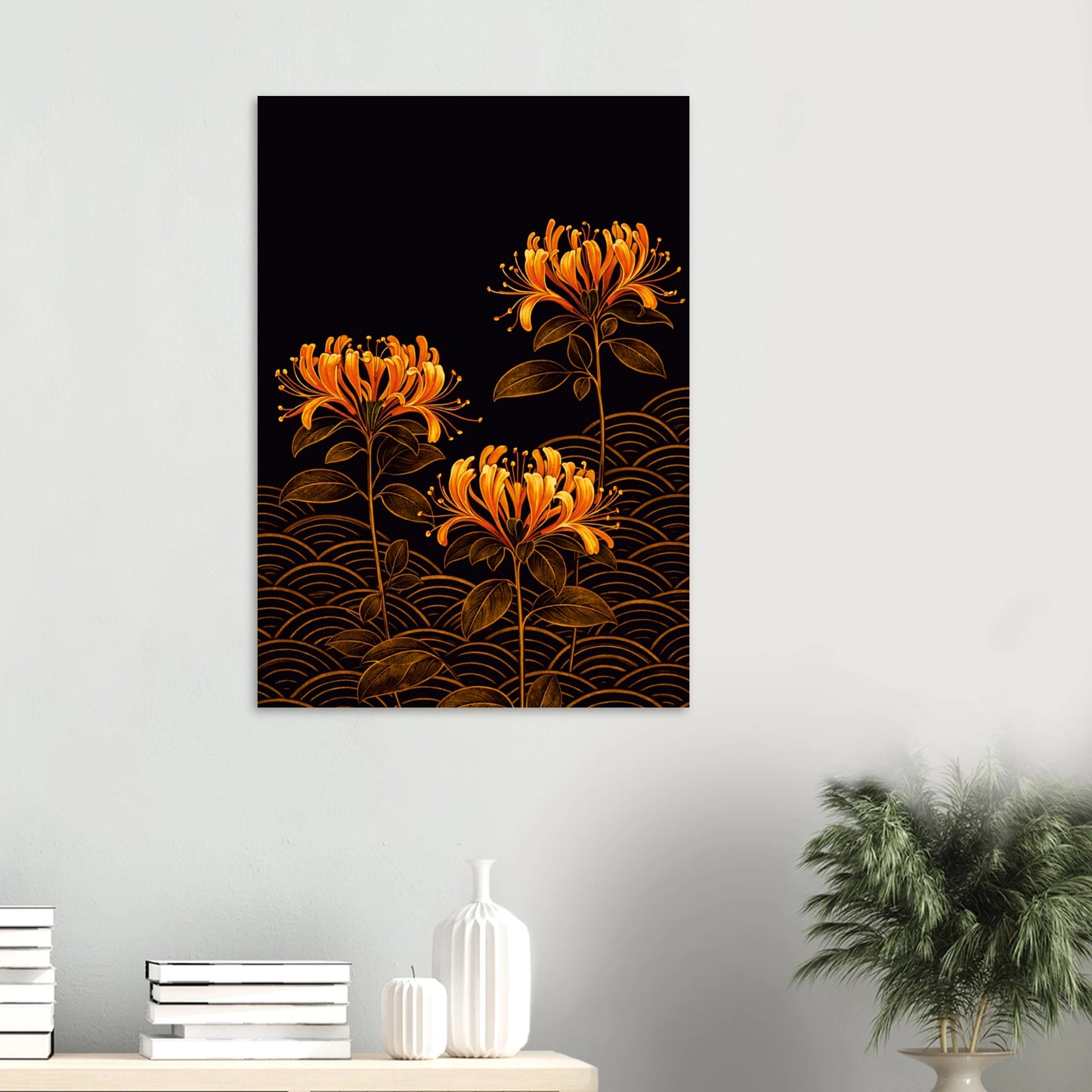 A vertical wall art print featuring three orange flowers with gold Japanese wave patterns on a black background, displayed on a light gray wall above a console table with books and a plant.