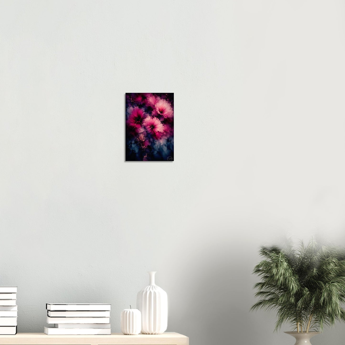 A vertical canvas art print featuring a dark, abstract floral design with vibrant pink and magenta flowers, displayed on a light gray wall above a console table with books and a potted plant.