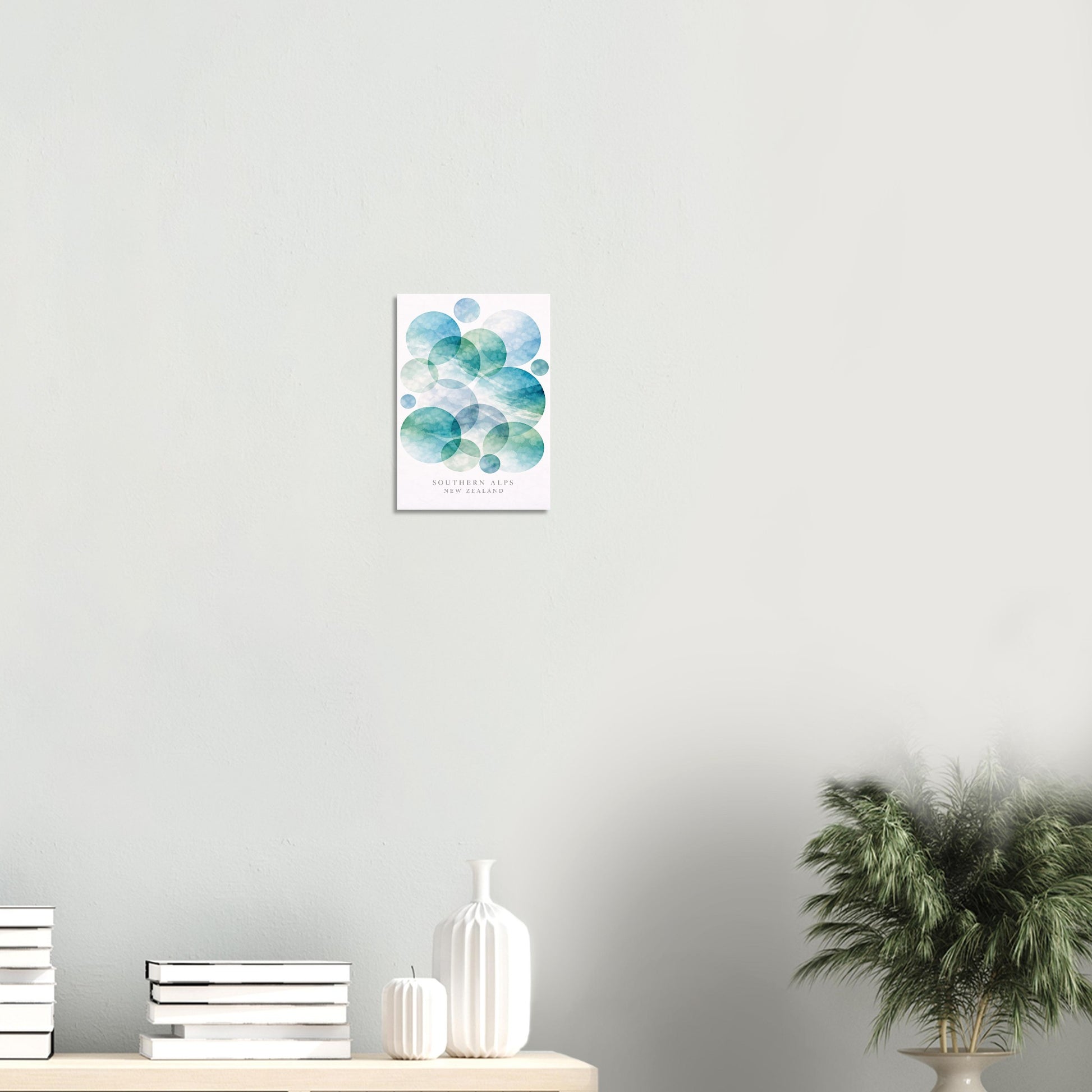 Abstract artwork on a wall with books and decor items below