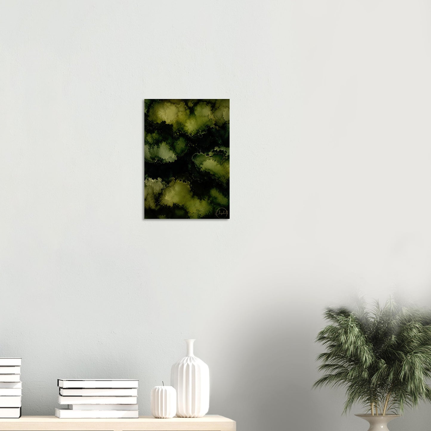 Framed black and white forest print on a wall above a shelf with decorative items.