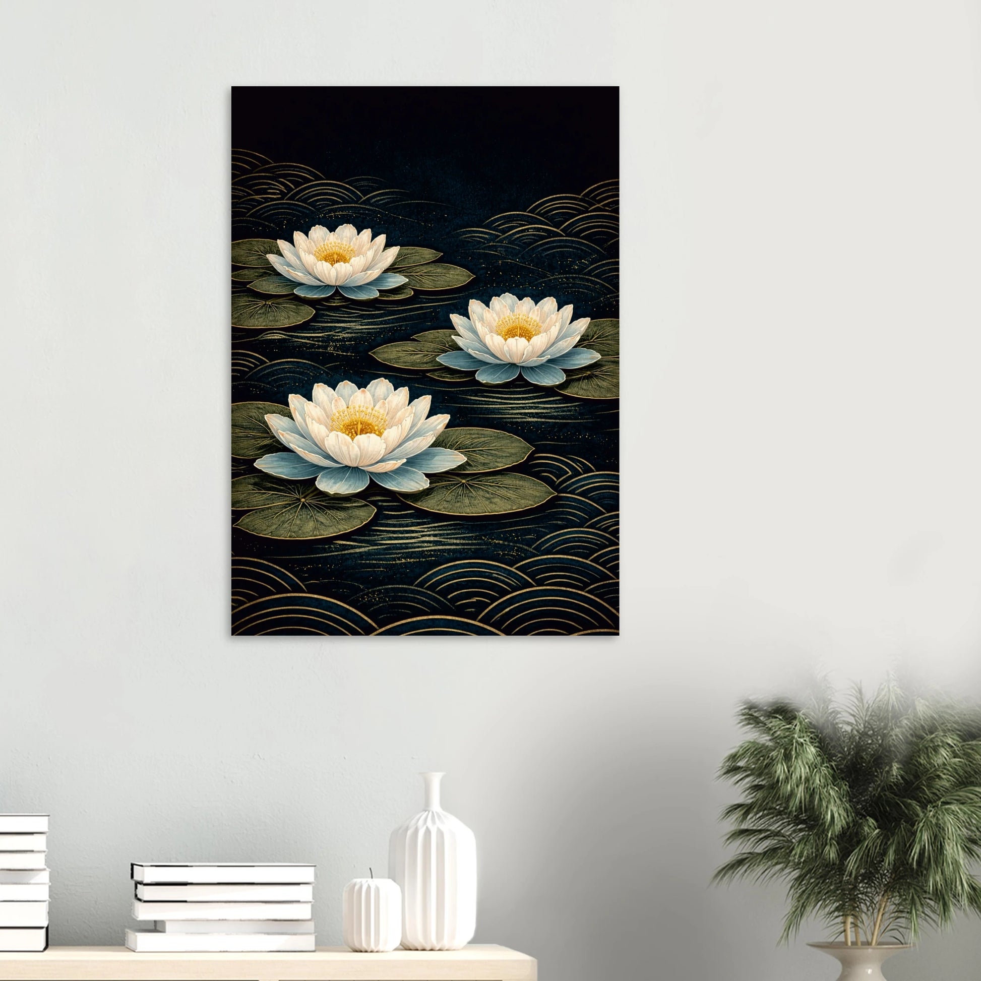 A vertical wall art print depicting three white water lilies on dark water with gold wave patterns, displayed on a light gray wall above a console table with books and a plant.