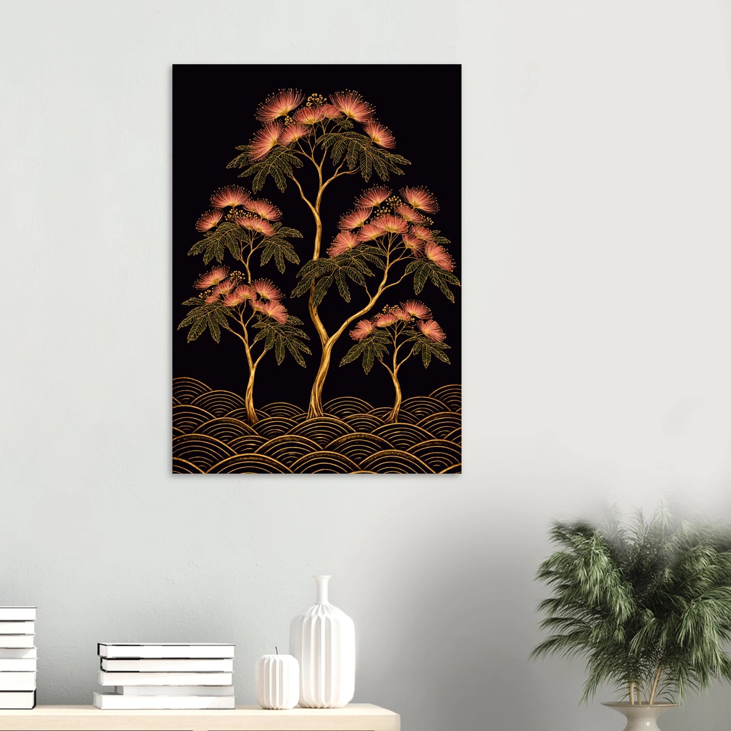A vertical wall art print depicting stylized trees with pink blossoms and gold wave-like patterns on a black background, displayed on a light gray wall above a console table with books, a vase, and a potted plant.