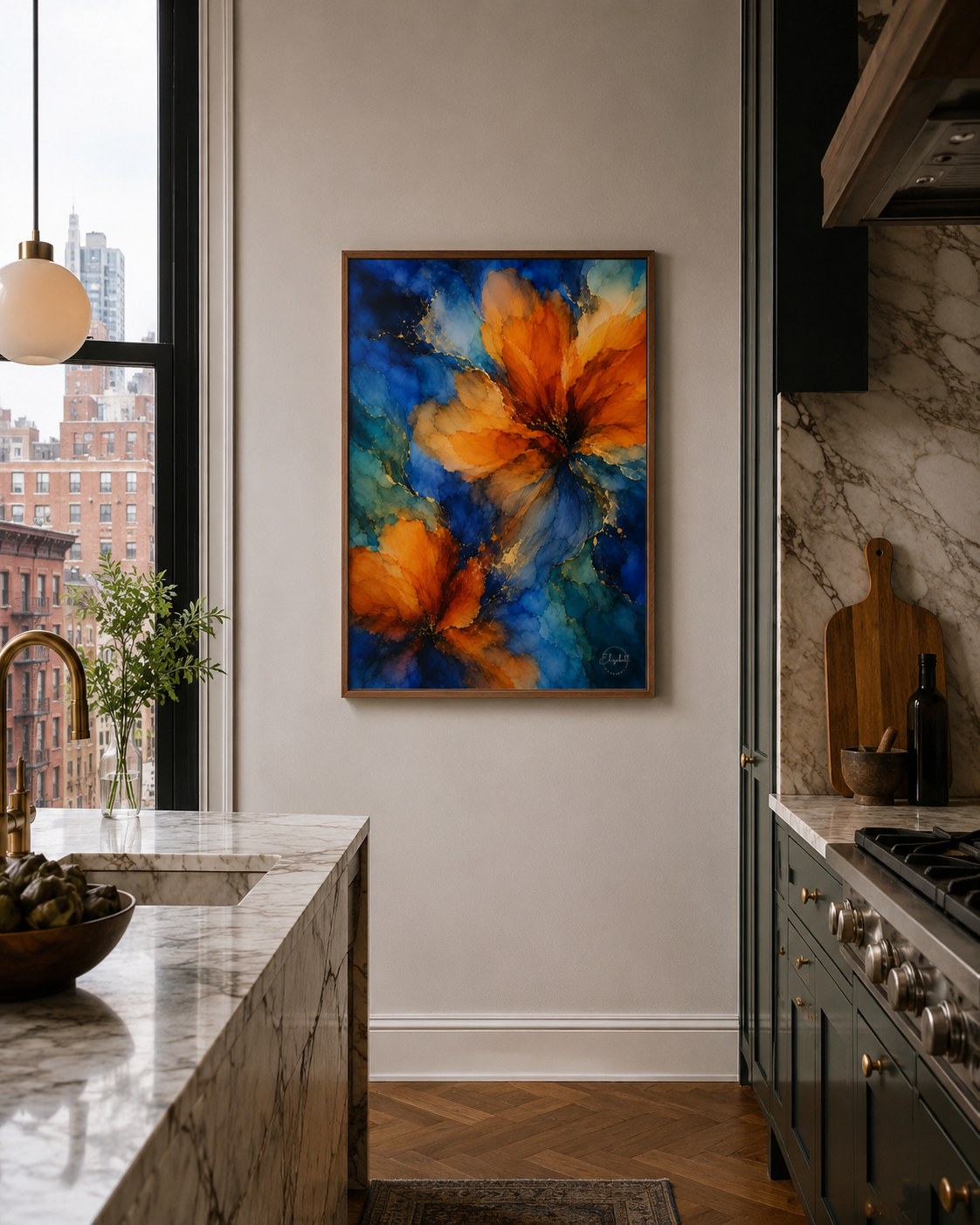 A framed abstract floral painting with vibrant orange and blue flowers hangs on a beige wall in a modern kitchen with marble countertops and dark cabinets.