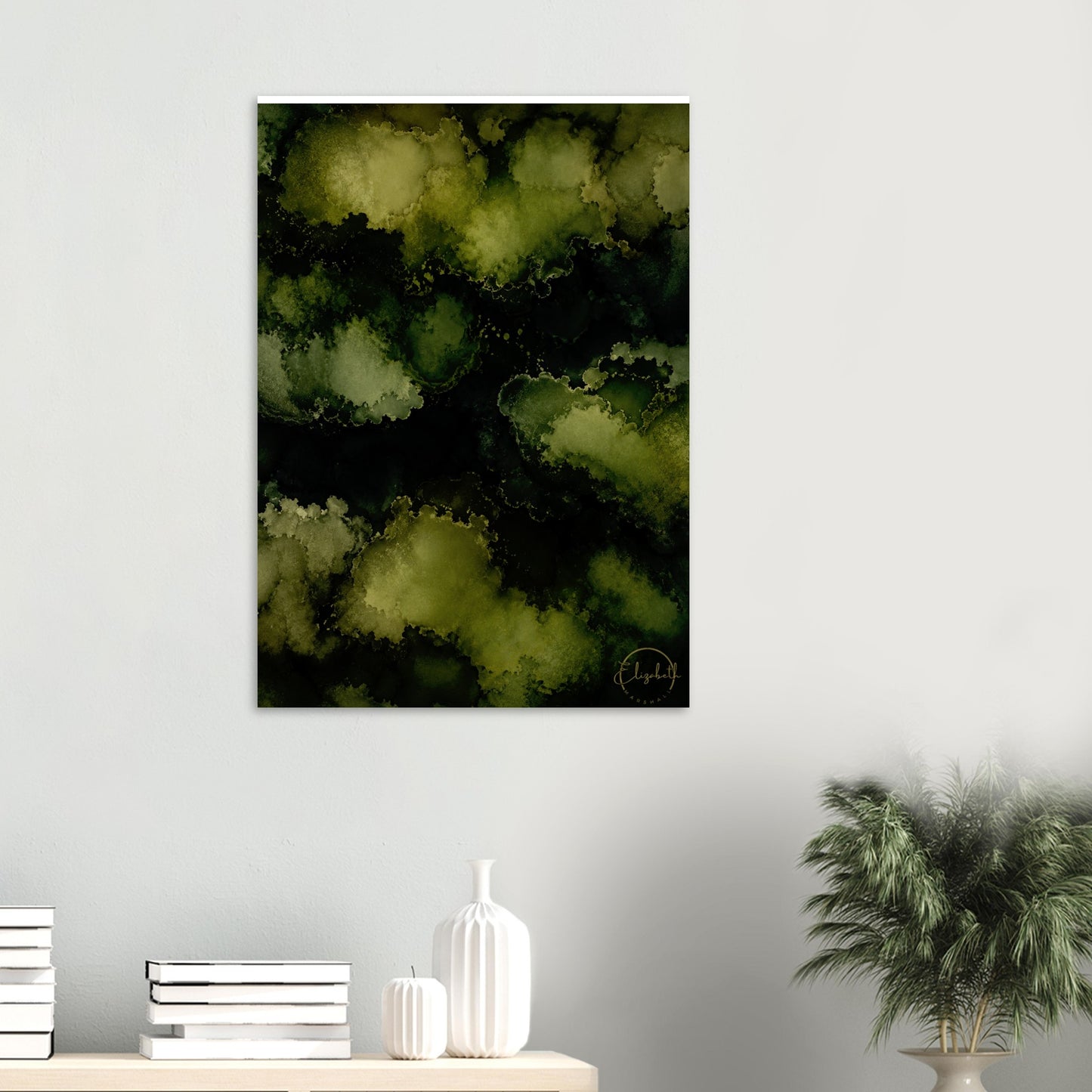 Abstract wall art featuring a dark green and black watercolor cloud pattern, displayed on a light gray wall above a console table with books, a white vase, and a potted plant.