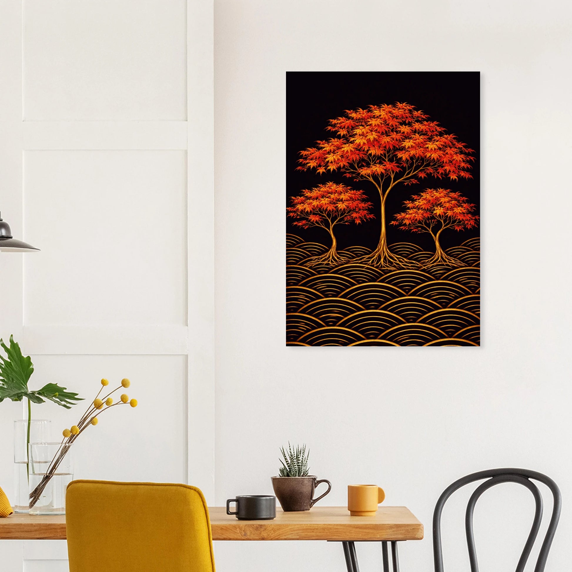 A vertical wall art print depicting three orange-red maple trees with gold wave-like patterns on a black background, displayed on a white wall above a dining table with chairs and mugs.