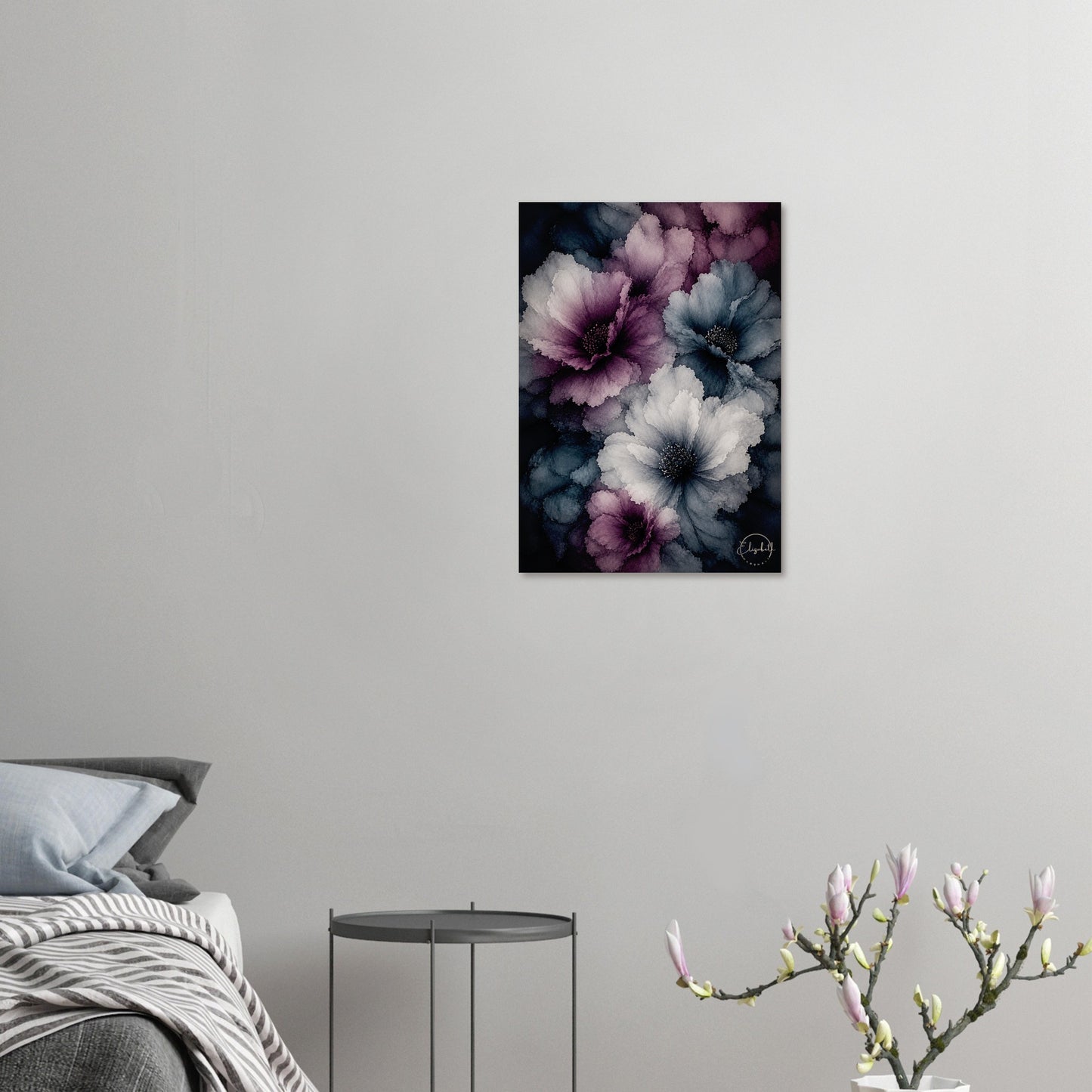 A vertical canvas wall art print featuring large watercolor-style flowers in purple, blue, and white on a dark background, displayed in a bedroom setting above a bed and side table.
