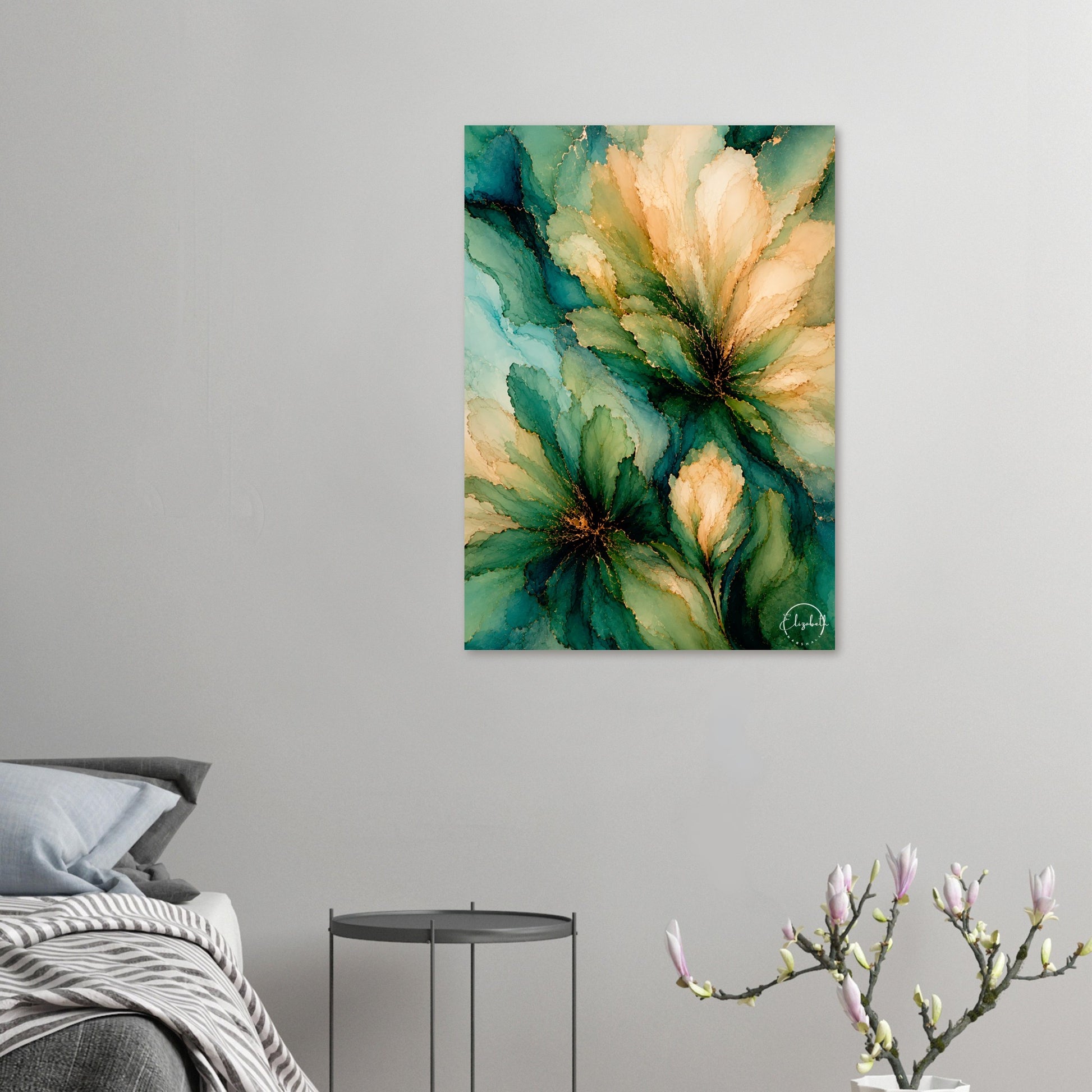 Abstract floral wall art hanging on a light gray bedroom wall above a bed, with a small side table and flowering branch in the foreground. The artwork features layered green, teal, and warm cream floral shapes with subtle gold speckles.