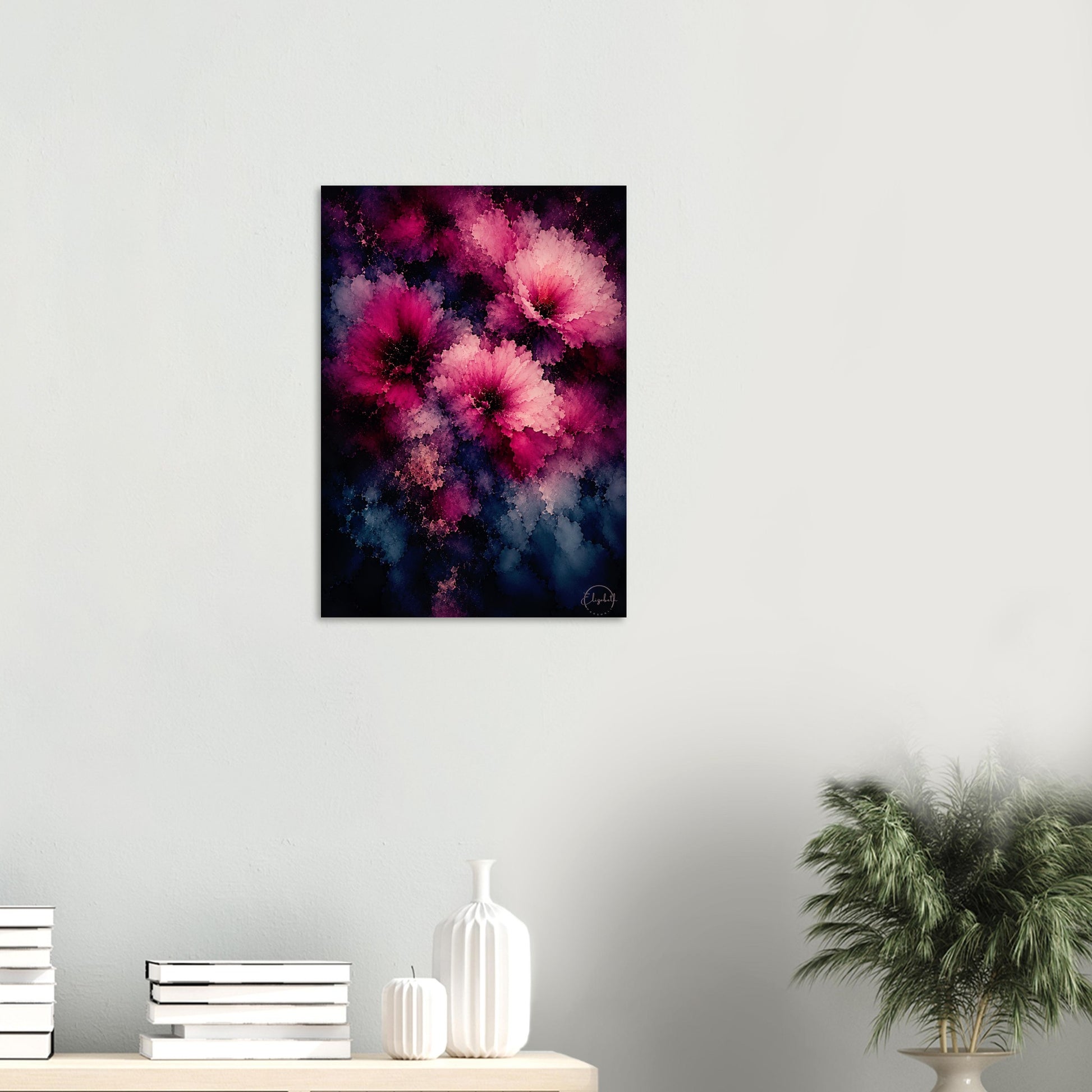 A vertical canvas wall art print featuring vibrant pink and magenta flowers against a dark navy and black background, displayed on a light gray wall above a styled shelf with books, white vases, and a potted plant.