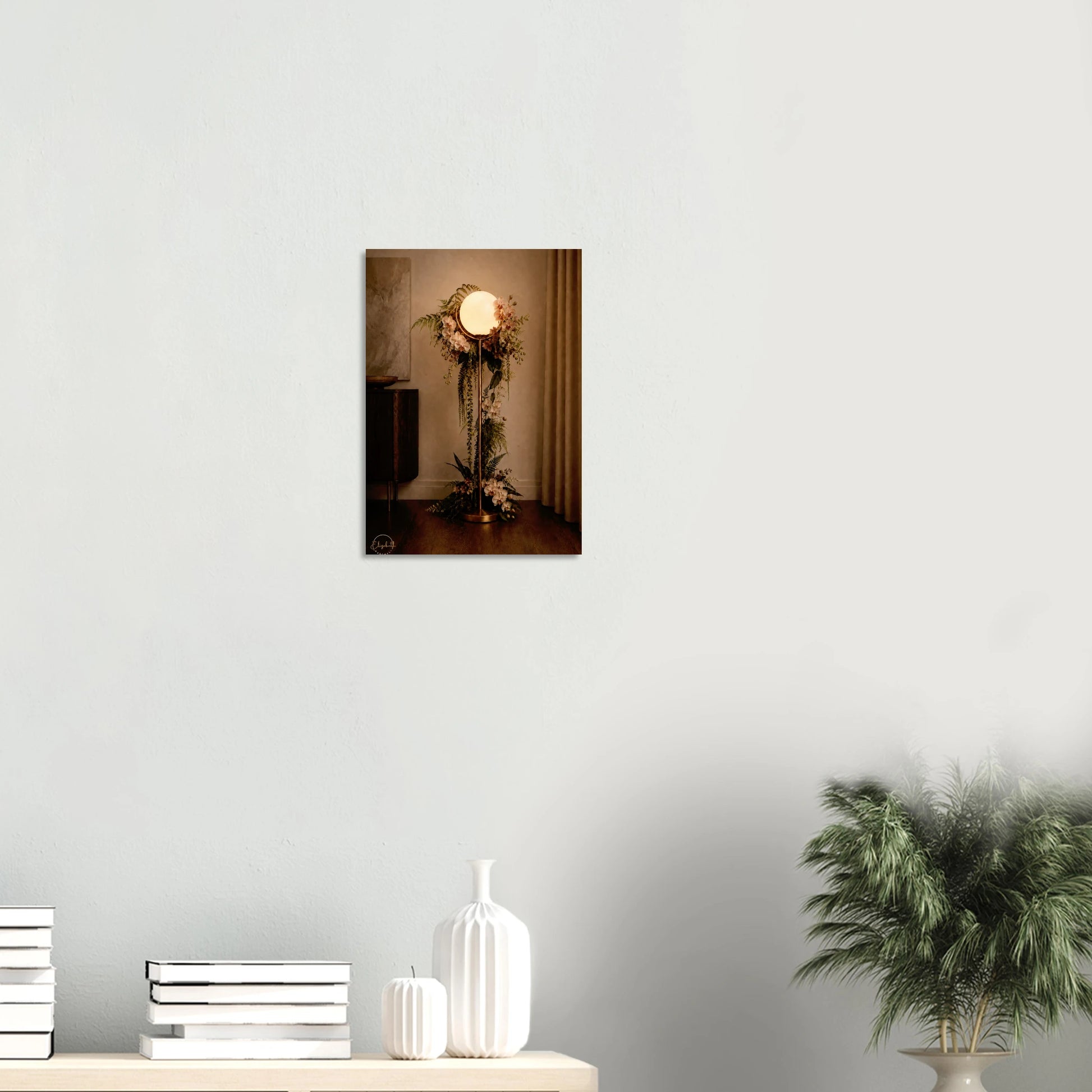 A vertical wall art print depicting a vintage-style floor lamp adorned with floral arrangements, displayed on a light gray wall above a console table with decorative vases and a potted plant.