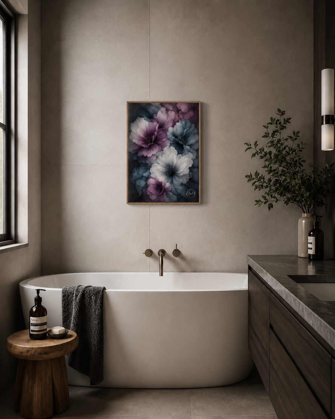 A framed floral wall art print with purple, blue, and white flowers hangs above a white freestanding bathtub in a modern bathroom with a wood vanity, dark towel, and window.