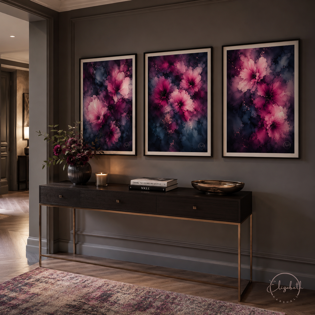 Three framed abstract floral wall art prints in pink, purple, and blue tones hang above a dark wood console table in a styled interior room.