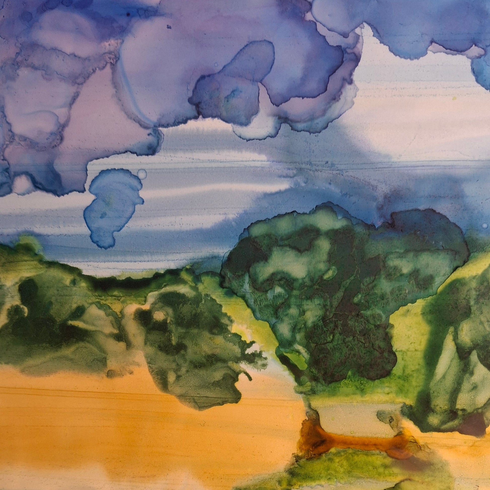 landscape painting featuring green trees, a golden field, and blue-purple clouds, shown on paper with a wooden support visible at the bottom.
