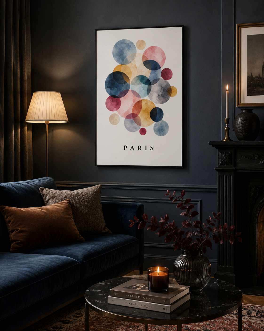 A framed wall art print featuring overlapping watercolor circles in blue, pink, yellow, and red tones above the word PARIS, displayed in a dark, elegant living room above a blue sofa.