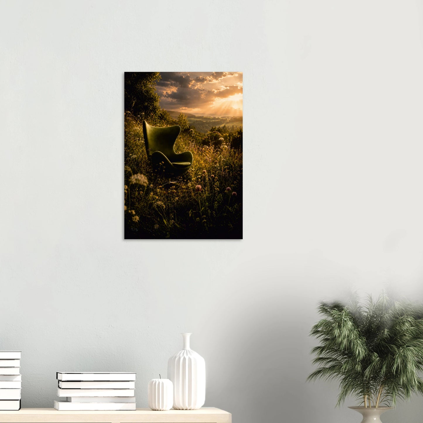 A vertical wall art print depicting a green chair in a sunlit grassy field at sunset, displayed on a light gray wall above a console table with books, white vases, and a potted plant.

Existential Crisis Sorted is for the moment you stop overthinking and simply sit down somewhere beautiful. An Egg Chair-inspired silhouette rests in a wild meadow at golden hour, surrounded by tumbling wildflowers, deep olive grasses and a sky that cannot decide between storm and sunset. It is moody, romantic, and deeply, qui