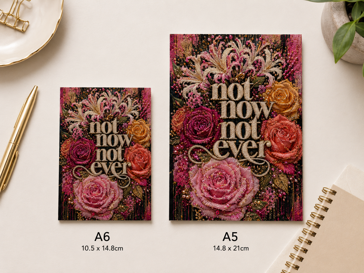 Two floral art prints with the text 'not now not ever' shown on a light beige desk surface, labeled A6 and A5 with dimensions underneath. The prints feature pink, red, orange, and cream flowers with ornate lettering.