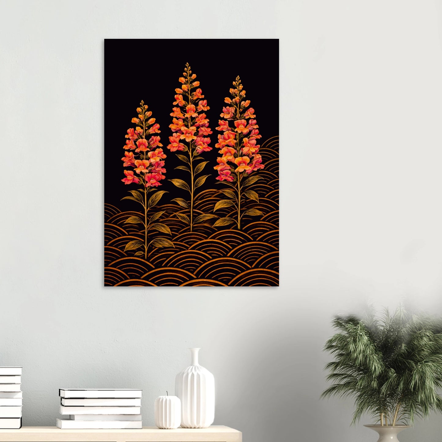 A vertical wall art print featuring three stylized orange and red flowers on a black background with gold wave patterns, displayed on a light gray wall above a console table with books, vases, and a potted plant.
