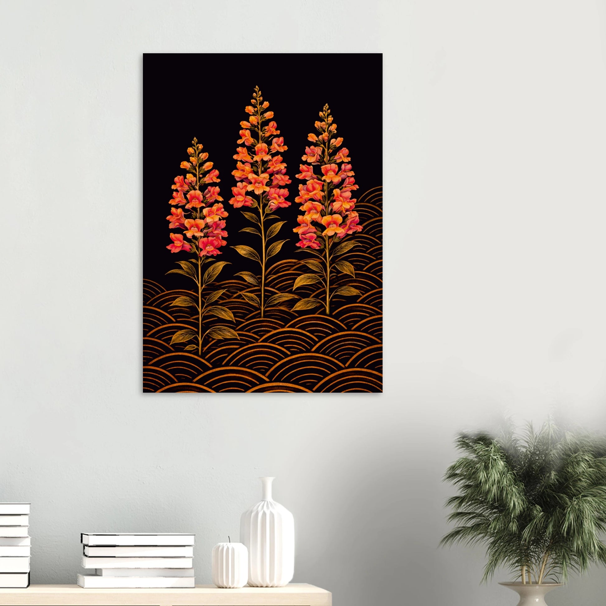 A vertical wall art print featuring three stylized orange and red flowers on a black background with gold wave patterns, displayed on a light gray wall above a console table with books, vases, and a potted plant.