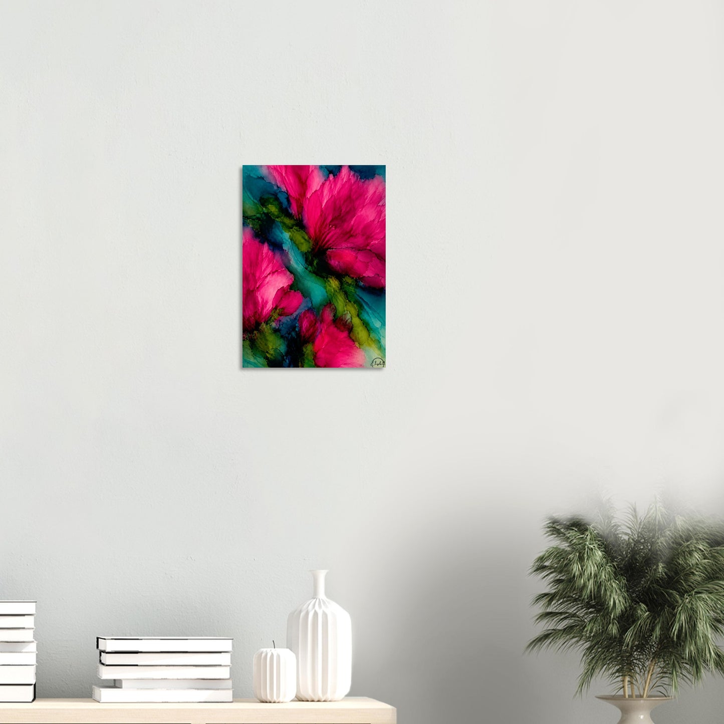 A vertical canvas art print featuring a vibrant abstract floral design with hot pink hibiscus-like flowers and teal/green watercolor washes, displayed on a light gray wall above a styled shelf with books, white vases, and a potted plant.