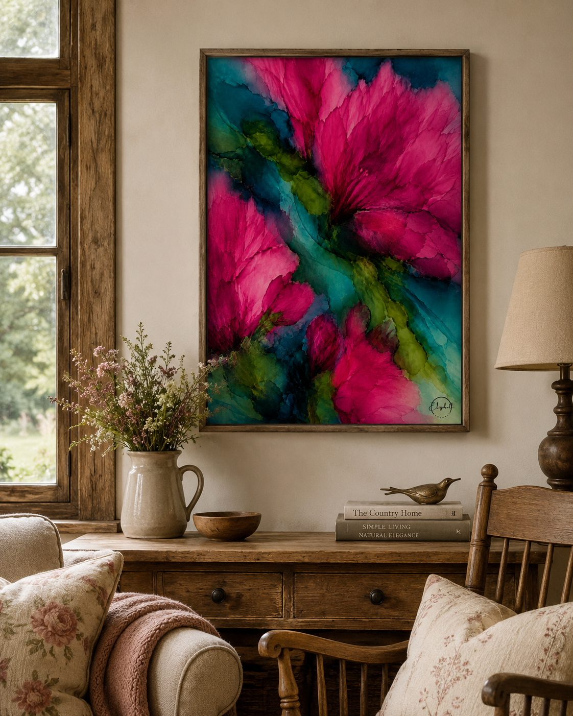 A framed abstract floral wall art print featuring vibrant pink and teal flowers with green accents, displayed in a rustic living room setting above a wooden console table.