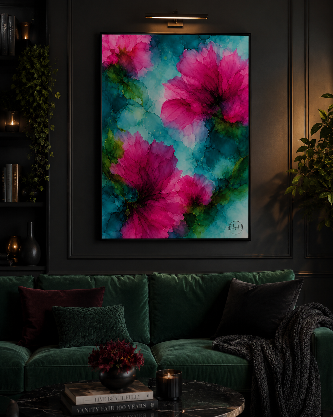 A framed abstract floral wall art print featuring large pink flowers on a teal and turquoise background, displayed above a dark green velvet sofa in a moody, dimly lit living room.